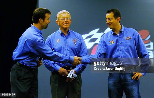 Joe Gibbs Racing team president J.D. Gibbs , shakes hands with Kyle Busch , driver of the M&M's Toyota, as team owner Joe Gibbs look on, after...