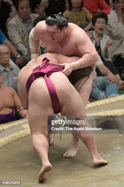 Mongolian yokozuna Hakuho throws komusubi Mitakeumi to win on day two of the Grand Sumo Summer Tournament at Ryogoku Kokugikan on May 14, 2018 in...