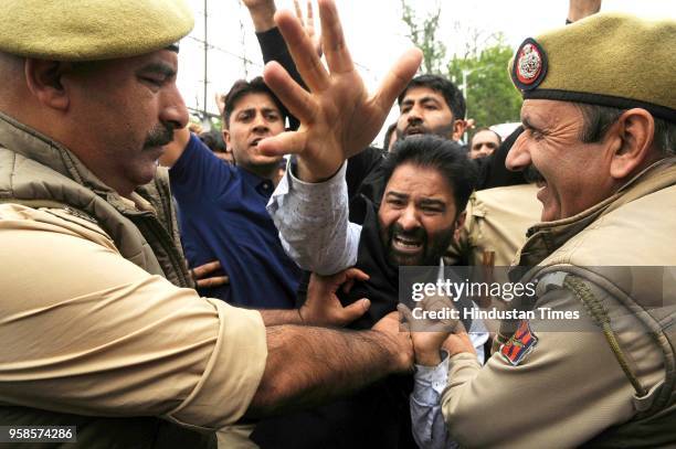 Government teachers of Kashmir shout slogans as police try to stop them during a protest on May 14, 2018 in Srinagar, India. Police used water...