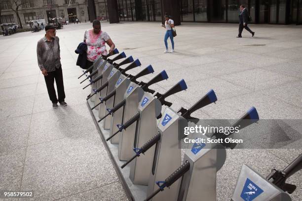 Marvin Mosley and Jonikka Raines look over the Chicago Gun Share Program art installation in the Daley Center plaza on May 14, 2018 in Chicago,...