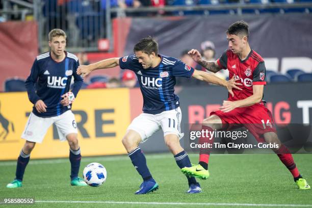 May 12: Kelyn Rowe of New England Revolution challenged by Jay Chapman of Toronto FC during the New England Revolution Vs Toronto FC regular season...