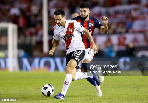 Ignacio Scocco of River Plate fights for the ball with Gabriel Gudiño of San Lorenzo during a match between River Plate and San Lorenzo as part of...