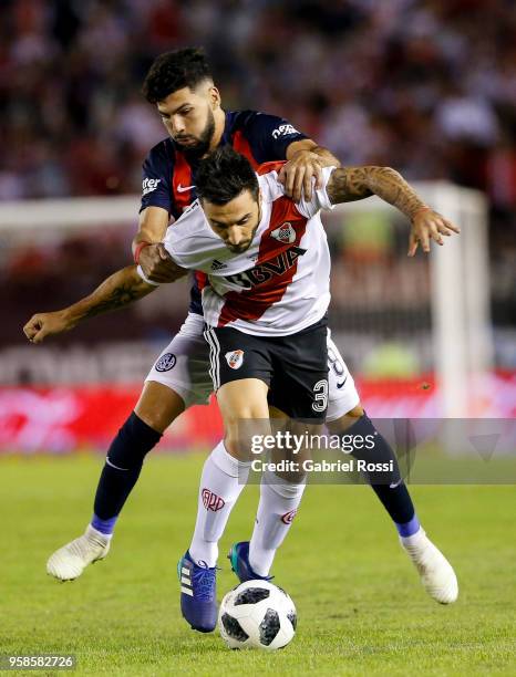 Ignacio Scocco of River Plate fights for the ball with Gabriel Gudiño of San Lorenzo during a match between River Plate and San Lorenzo as part of...