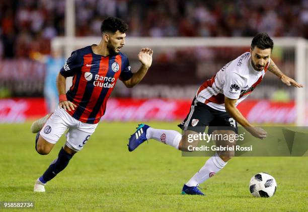 Ignacio Scocco of River Plate fights for the ball with Gabriel Gudiño of San Lorenzo during a match between River Plate and San Lorenzo as part of...