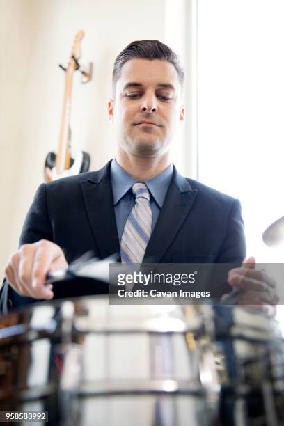 low angle view of man playing drum in studio - instrument à percussion photos et images de collection