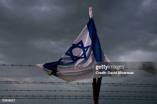 An Israeli flag, drenched by the rains, is caught uo in the barbed wire surrounding the Qasr al Yahud baptism site on January 18, 2010 near Jericho...