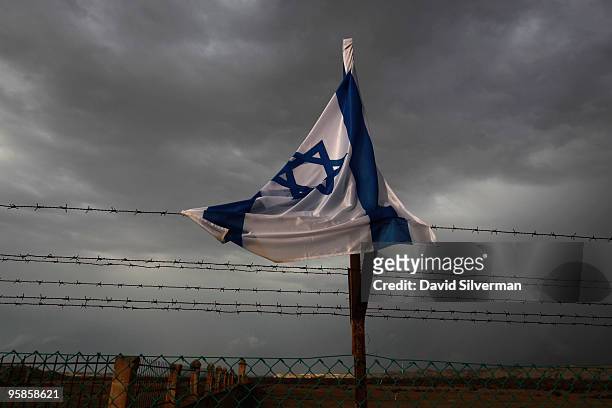 An Israeli flag, drenched by the rains, is caught uo in the barbed wire surrounding the Qasr al Yahud baptism site on January 18, 2010 near Jericho...