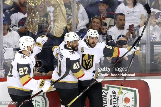 Tomas Tatar of the Vegas Golden Knights is congratulated by his teammates Shea Theodore and Pierre-Edouard Bellemare after scoring a first period...