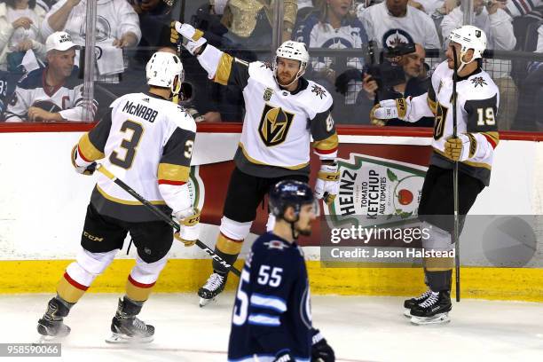 Mark Scheifele of the Winnipeg Jets reacts as Jonathan Marchessault is congratulated by his teammates Brayden McNabb and Reilly Smith of the Vegas...