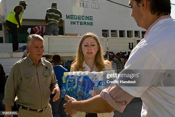 In this handout image provided by the United Nations Stabilization Mission in Haiti , Chelsea Clinton helps unload water from a UN truck at the...