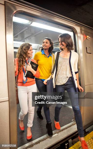 friends talking while disembarking from train - gå i land bildbanksfoton och bilder