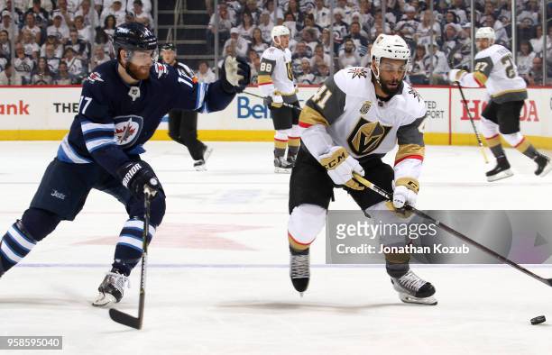Pierre-Edouard Bellemare of the Vegas Golden Knights plays the puck down the ice as Adam Lowry of the Winnipeg Jets defends during first period...
