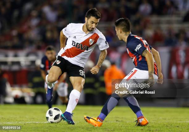 Ignacio Scocco of River Plate fights for the ball with Gabriel Rojas of San Lorenzo during a match between River Plate and San Lorenzo as part of...