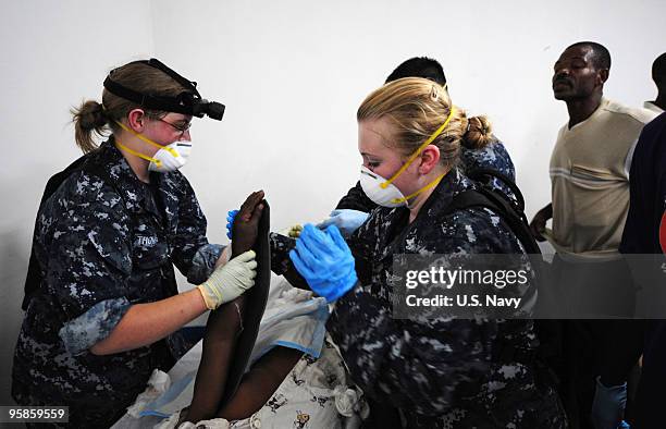 In this handout image provided by the U.S. Navy, U.S. Navy Sailors treat earthquake victims at the Killick Haitian Coast Guard Base clinic January...