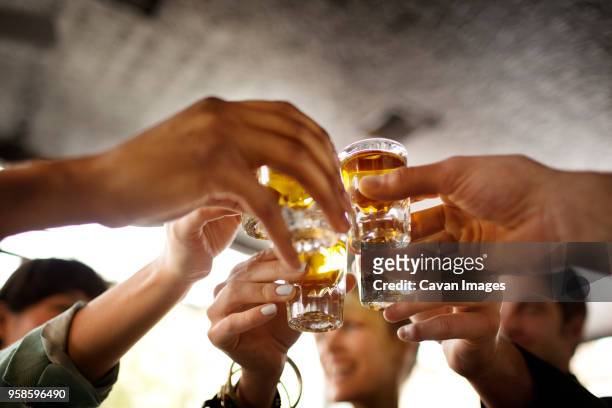 friends enjoying tequila in bar - superalcolico foto e immagini stock