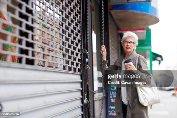 woman looking away while standing against store - menselijke rol stockfoto's en -beelden