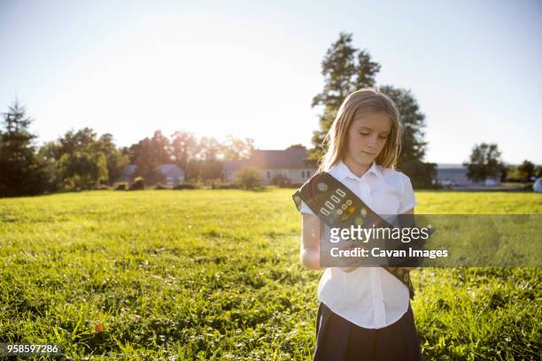 schoolgirl using tablet computer while standing on grassy field - sash stock pictures, royalty-free photos & images