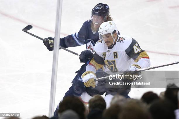 Luca Sbisa of the Vegas Golden Knights is checked into the boards by Patrik Laine of the Winnipeg Jets during the second period in Game Two of the...