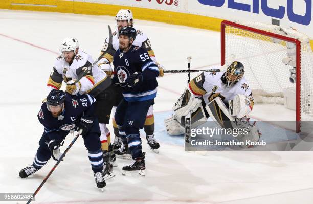 Goaltender Marc-Andre Fleury of the Vegas Golden Knights looks around a screen set by teammates Brayden McNabb and James Neal as they battle for...