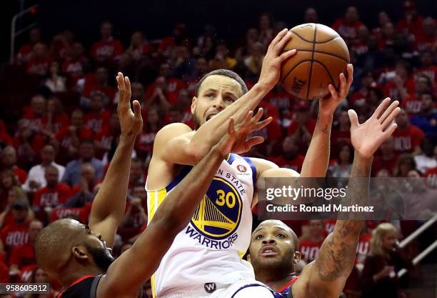 Stephen Curry of the Golden State Warriors drives to the basket in the second half against Chris Paul and PJ Tucker of the Houston Rockets in Game...