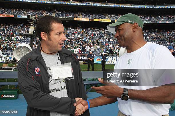 Actor Adam Sandler meets with wide receivers coach Henry Ellard of the New York Jets on the sideline before the start of the AFC Divisional Playoff...