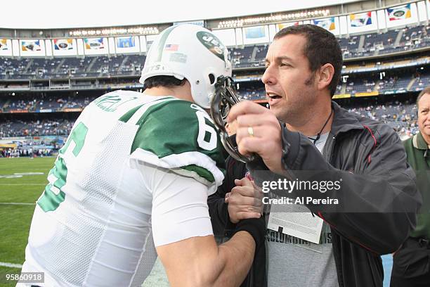 Actor Adam Sandler meets with Quarterback Mark Sanchez of the New York Jets on the sideline before the start of the AFC Divisional Playoff game...