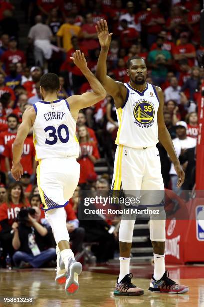 Stephen Curry and Kevin Durant of the Golden State Warriors react late in the game against the Houston Rockets in Game One of the Western Conference...