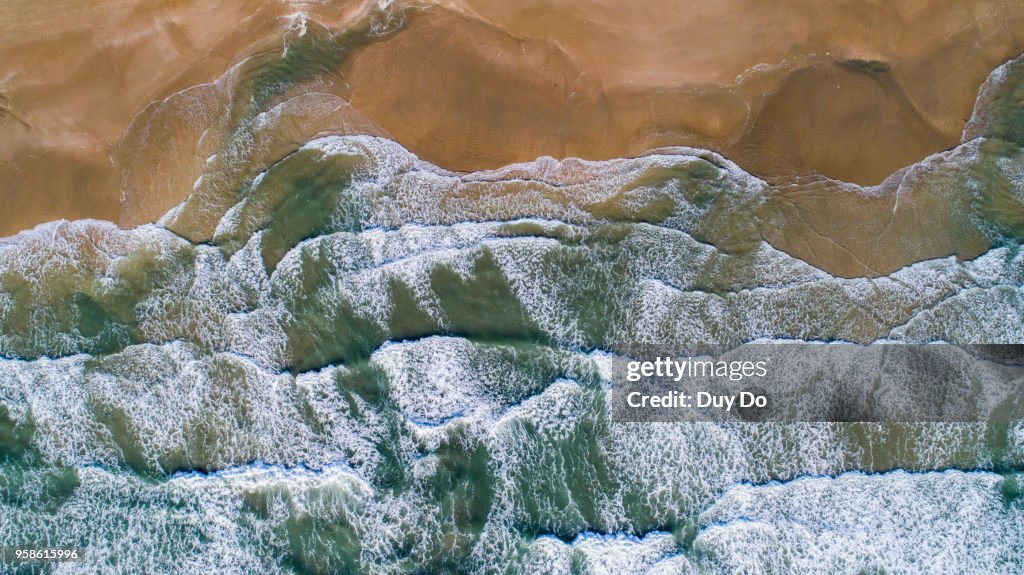High view of beautiful sea wave with yellow sand beach.
