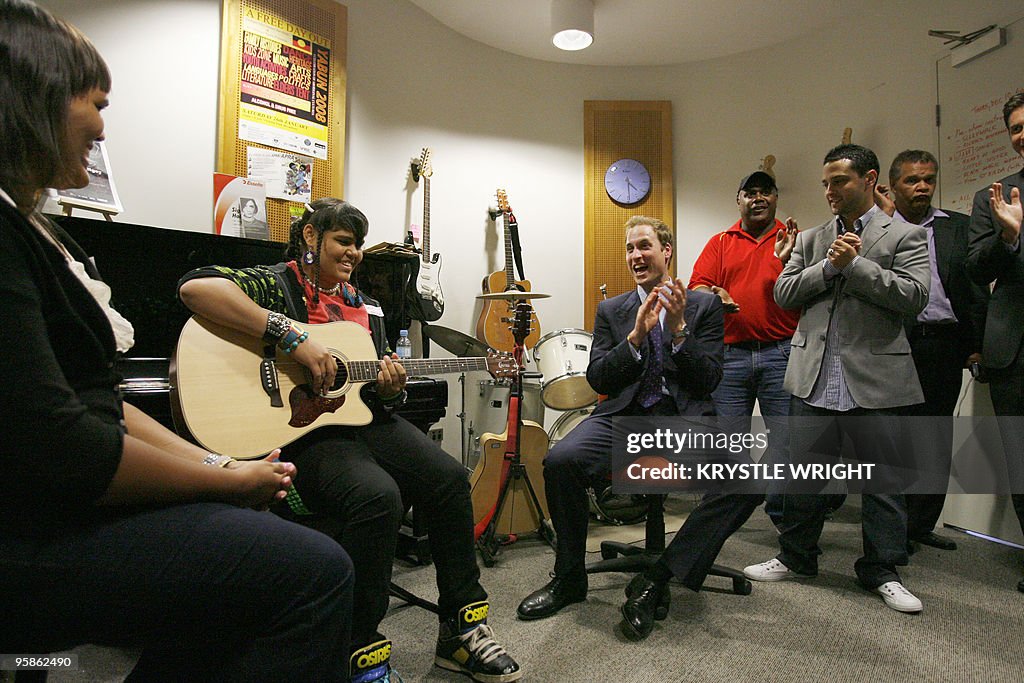 Britain's Prince William (C) listens to