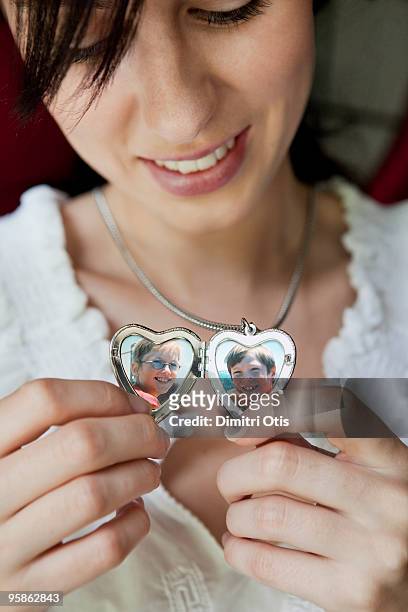 woman showing her children in locket - open collar stockfoto's en -beelden