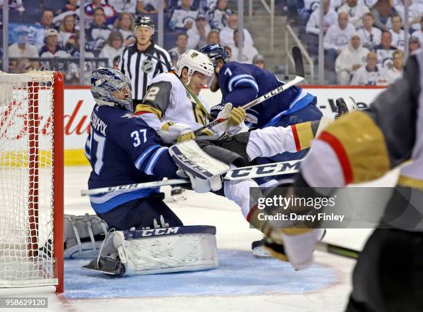 Ben Chiarot of the Winnipeg Jets knocks Tomas Nosek of the Vegas Golden Knights into goaltender Connor Hellebuyck during third period action in Game...