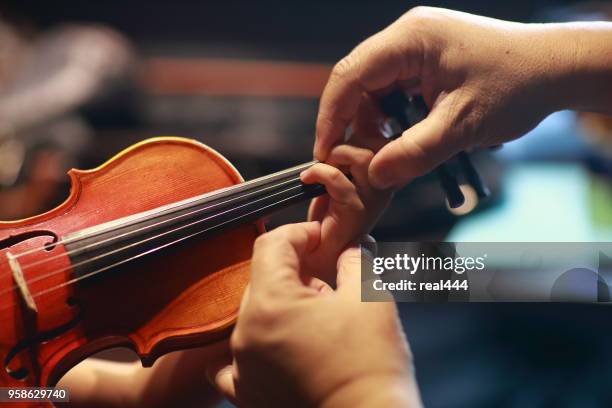 een persoon spelen van de viool weergegeven: handen met de boeg - orkestmuziek uit de barok stockfoto's en -beelden