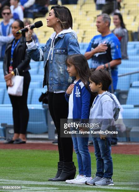 Courtney Lopez stands with children Gia and Nico as she sings the National Anthem before the game between the Los Angeles Dodgers and the Cincinnati...