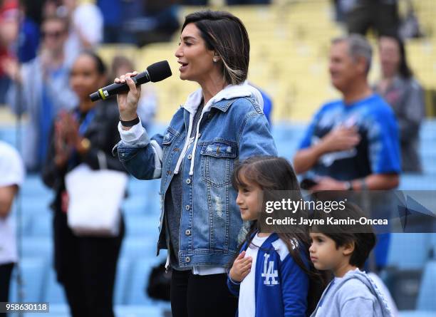 Courtney Lopez stands with children Gia and Nico as she sings the National Anthem before the game between the Los Angeles Dodgers and the Cincinnati...
