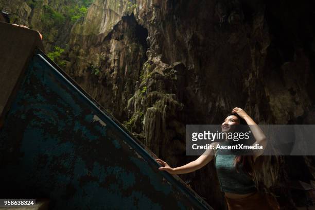 female tourist visiting the batu caves near kuala lumpur, malaysia - batu caves stock pictures, royalty-free photos & images