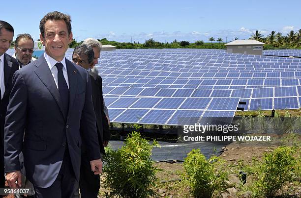 French President Nicolas Sarkozy walks past solar panels as he visits a solar plant for its opening in Saint-Pierre de La Reunion island on January...