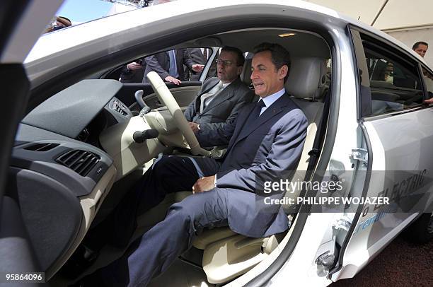 France's President Nicolas Sarkozy and Patrick Pelata , and French automaker Renault's Chief Operating Officer, sit in an electric powered Renault...