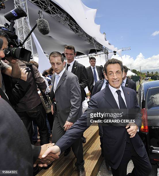 French President Nicolas Sarkozy shakes hand suring his visit for the openning of a solar plant in Saint-Pierre de La Reunion island on January 19,...