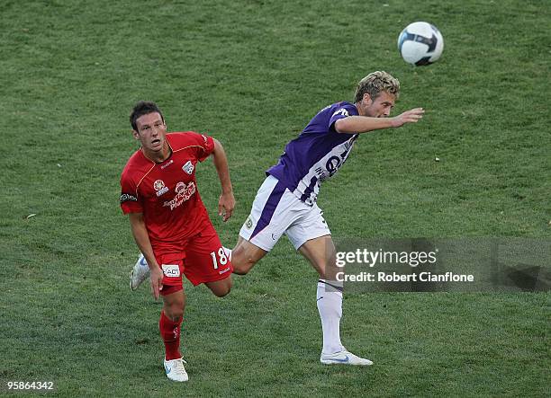 Jamie Coyne of Perth Glory is pressured by Fabian Barbiero of Adelaide United during the round 19 A-League match between Adelaide United and Perth...