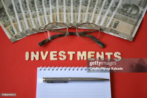 indian rupee notes with word "investment" - rupee stock pictures, royalty-free photos & images