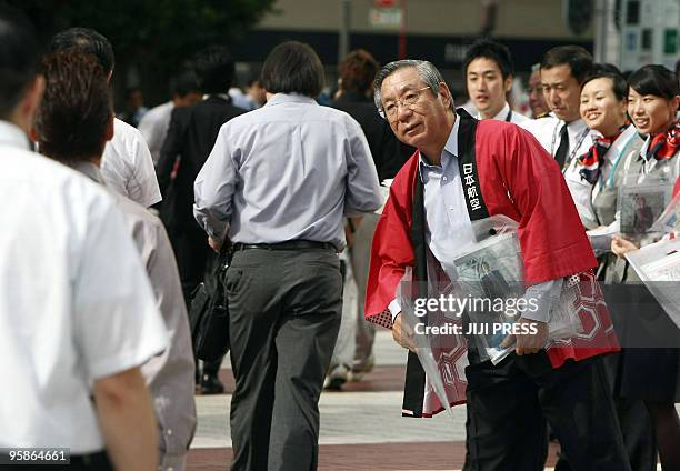 Japan Airlines president Haruka Nishimatsu , dressed in a "happi coat", hands out leaflets to promote the company to commuters in Tokyo on September...