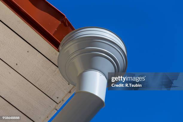 rain gutter on house with blue sky in the background - overhangende rots stockfoto's en -beelden