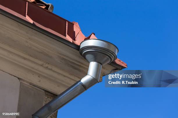 rain gutters on old home. there is a blue sky in the background. - rock overhang stock pictures, royalty-free photos & images