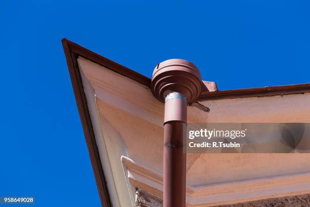 rain gutters on old home. there is a blue sky in the background. - rock overhang imagens e fotografias de stock
