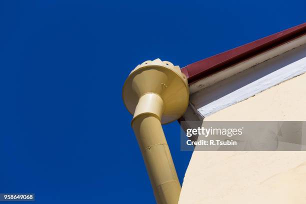 rain gutters on old home. there is a blue sky in the background. - rock overhang stock pictures, royalty-free photos & images