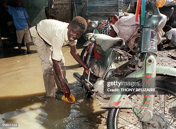 Homeless Haitian child washes a motorcycle in the slum area of Cite Soleil in Port-au-Prince, Haiti, 30 October 1998, as he tries to earn a few...