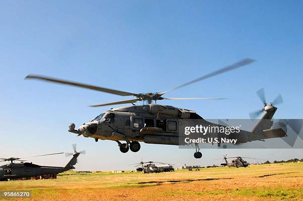 In this handout image provided by the US Navy, An SH-60S helicopter assigned to the Nimitz-class aircraft carrier USS Carl Vinson lands at the...