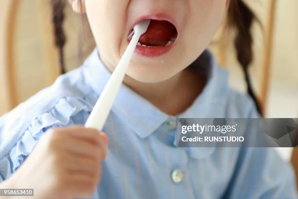 close up of little girl brushing teeth - 歯みがき粉 ストックフォトと画像