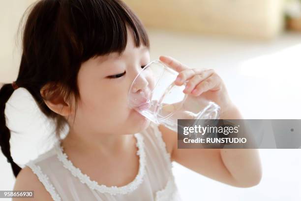 close up of little girl drinking glass of water - purity stock pictures, royalty-free photos & images