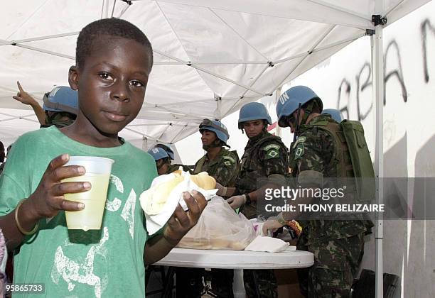 Soldiers in Haiti distribute food and water in the Cite Soleil slum of Port-au-Prince onInternational Water Day. AFP PHOTO/Thony BELIZAIRE